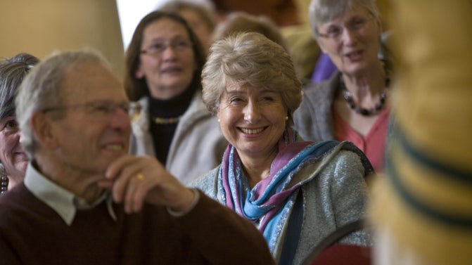 A close-up of a group of people enjoying a talk at Petworth, focused on a smiling visitor.